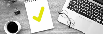 Busy desktop with checklist on notepad